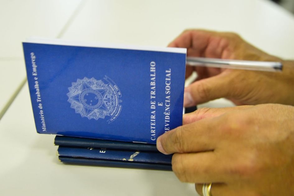 Pessoa assinando uma carteira de trabalho