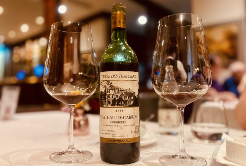 Garrafa de vinho em mesa de restaurante com duas taças de cada lado
