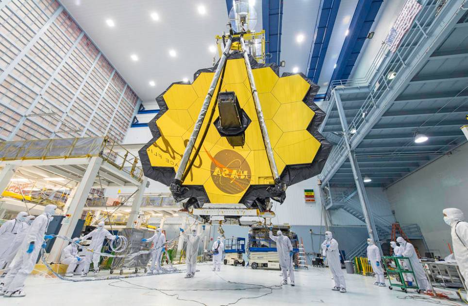 Os técnicos da NASA levantam o telescópio James Webb, usando um guindaste