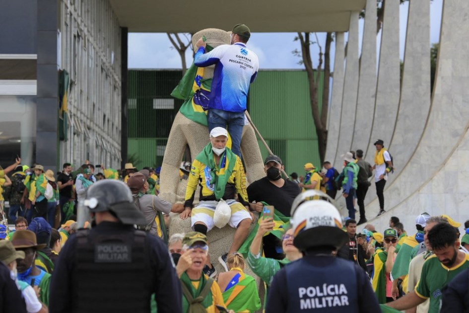 Homens sobem na estátua do STF
