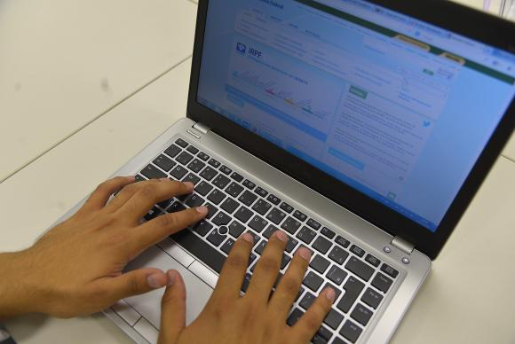 Mãos sobre teclado de notebook