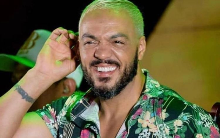 Belo em um show com a mão no ouvido