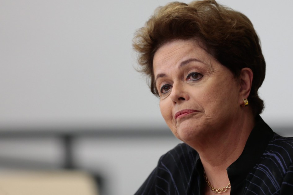 Mulher de cabelos catanhos e roupa preta de perfil