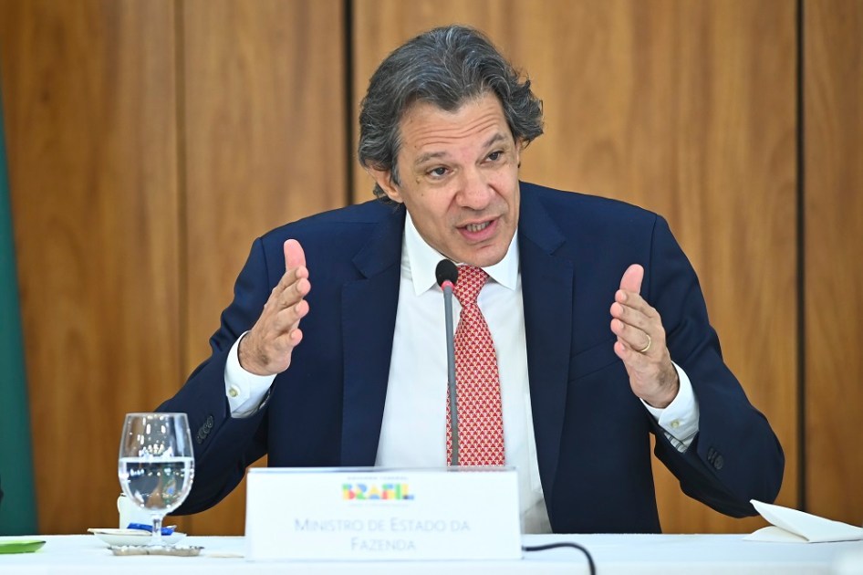 Fernando Haddad gesticula sentado durante evento do governo
