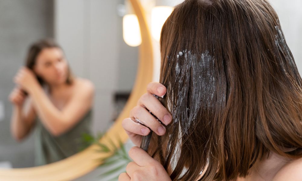 jovem-mulher-aplicando-produto-no-cabelo-freepik