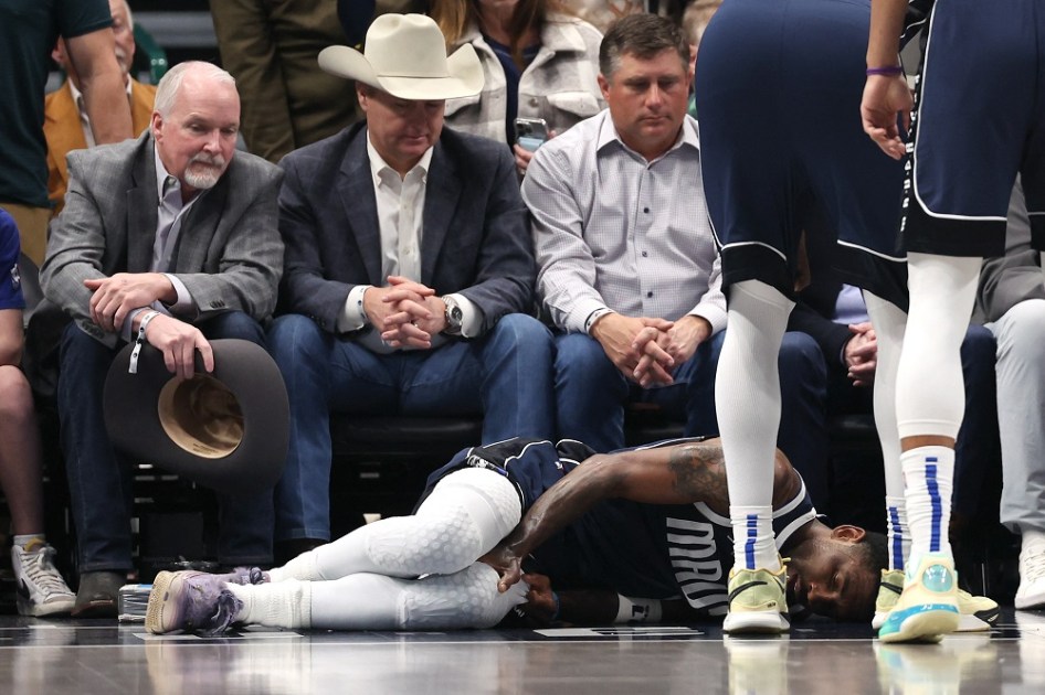 Kyrie Irving #11, do Dallas Mavericks, está caído na quadra após sofrer uma lesão no primeiro tempo contra o Sacramento Kings, no American Airlines Center