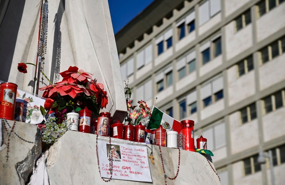 Velas aos pés da estátua do Papa João Paulo II na entrada do Hospital Gemelli, onde o Papa Francisco está internado