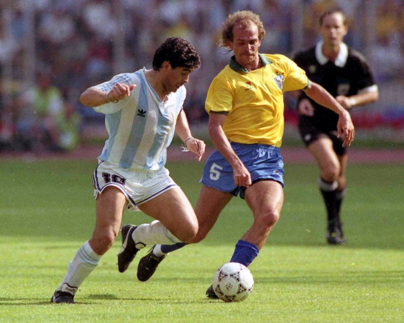O jogador argentino de futebol, Diego Maradona (e), disputa bola com o jogador brasileiro Alemão (Ricardo Rogério de Brito), durante partida válida pela segunda rodada da Copa do Mundo de 1990, em Turim