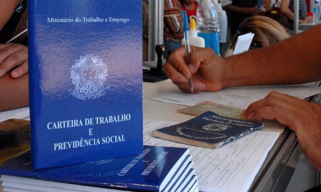 Pessoa assinando carteira de trabalho
