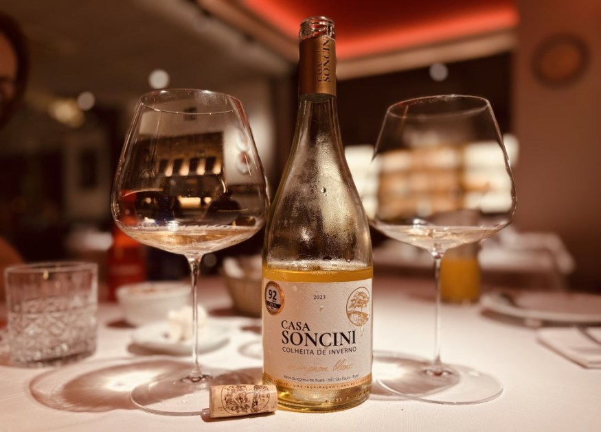 Garrafa de vinho à mesa ao lado de taça