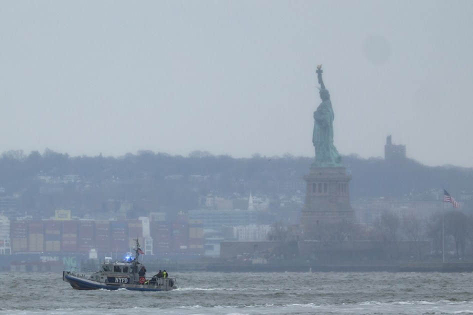 Um barco de resgate do Departamento de Polícia de Nova York é visto próximo à Estátua da Liberdade, em Nova York, após a queda de um helicóptero no rio Hudson