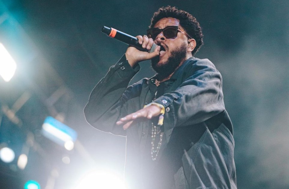 Emicida gesticula e segura o microfone com a mão esquerda enquanto canta no palco do Lollapalooza