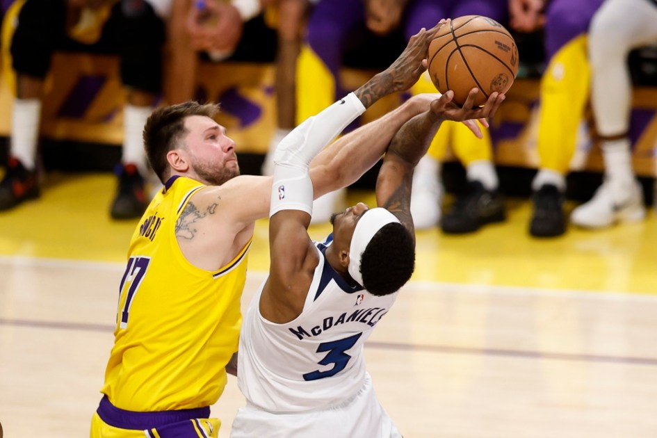 O armador do Los Angeles Lakers, Luka Doncic (à esq.), tenta bloquear o ala do Minnesota Timberwolves, Jaden McDaniels (à dir.)