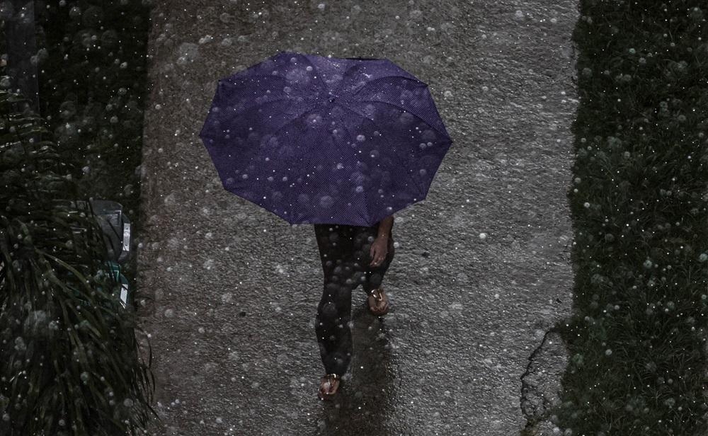 Pedestre caminha durante chuva na zona norte da capital paulista