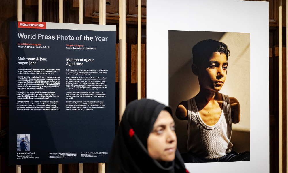 World Press Photo of 2025 award winner Palestinian photojournalist Samar Abu Elouf poses next to her winning photograph