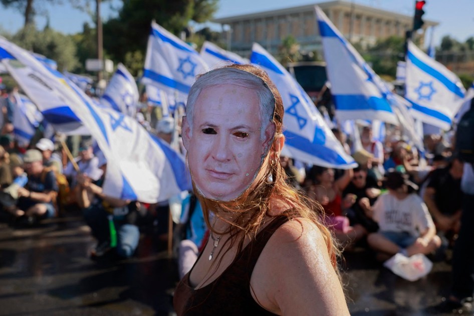 Um manifestante usando uma máscara representando o primeiro-ministro israelense Benjamin Netanyahu participa de uma manifestação para bloquear a entrada do Knesset, o parlamento de Israel