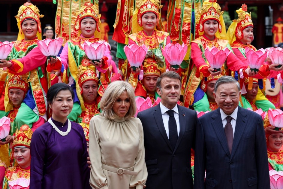 O secretário-geral do Partido Comunista do Vietnã, To Lam, e sua esposa, Ngo Phong Ly, junto com o presidente francês, Emmanuel Macron, e sua esposa, Brigitte Macron, posam para uma foto com dançarinos tradicionais durante um almoço no Van Mieu, em Hanói