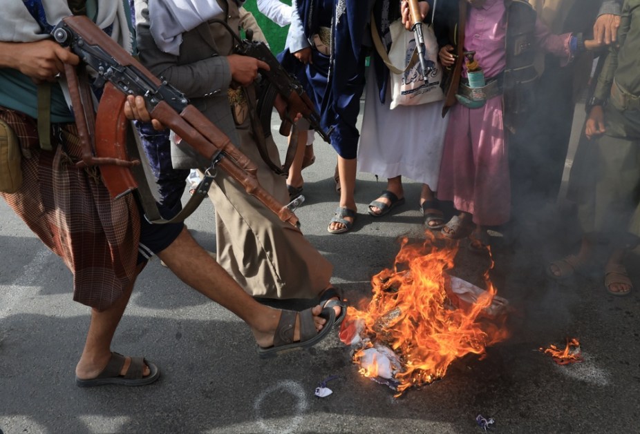 Apoiadores houthis queimam bandeiras dos Estados Unidos e de Israel durante protesto contra os bombardeios israelenses ao Irã