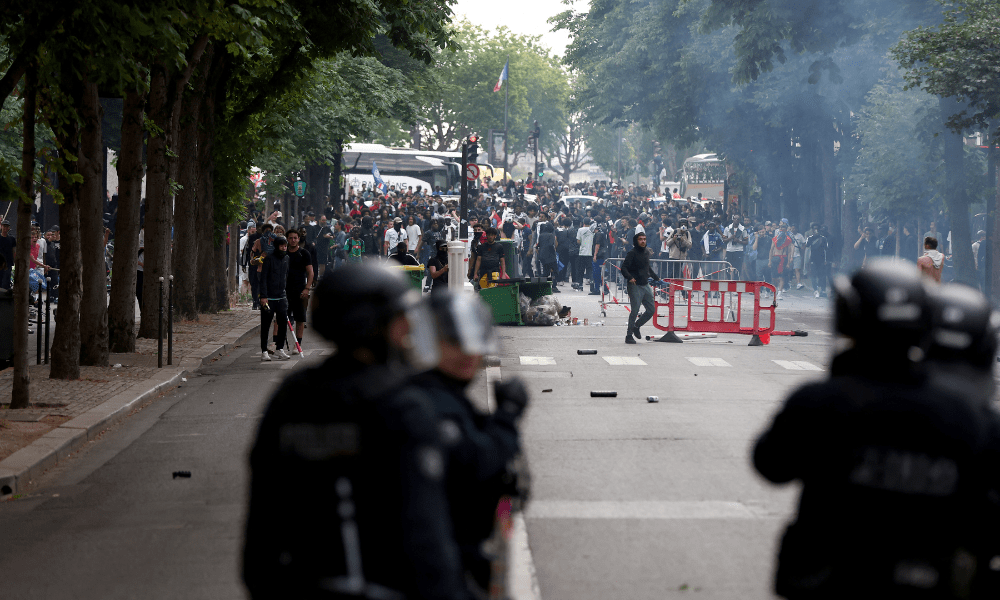 Policiais entram em confronto com a multidão após o desfile do ônibus do time do PSG, nas proximidades da avenida Champs-Elysées, em Paris, em 1º de junho de 2025, um dia após o PSG vencer a final da Liga dos Campeões da UEFA 2025 contra a Inter de Milão, em Munique. (Foto de Romain PERROCHEAU / AFP)