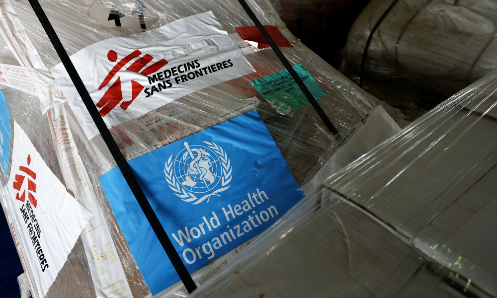 Os logotipos da MSF (Médicos Sem Fronteiras) e da Organização Mundial da Saúde (OMS) são vistos em suprimentos humanitários para Gaza, armazenados em armazéns do Crescente Vermelho Egípcio, na cidade fronteiriça egípcia de El-Arish, em 8 de abril de 2025. (Foto de Benoit Tessier / POOL / AFP)