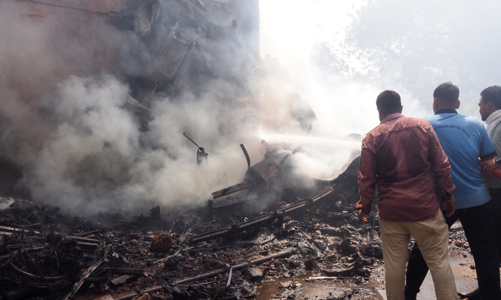 Bombeiros retiram o corpo de uma vítima após a queda do voo 171 da Air India em uma área residencial próxima ao aeroporto de Ahmedabad, no oeste da Índia, em 12 de junho de 2025. A aeronave, com destino a Londres, transportava 242 pessoas quando caiu. A companhia aérea classificou o desastre como um “acidente trágico”.