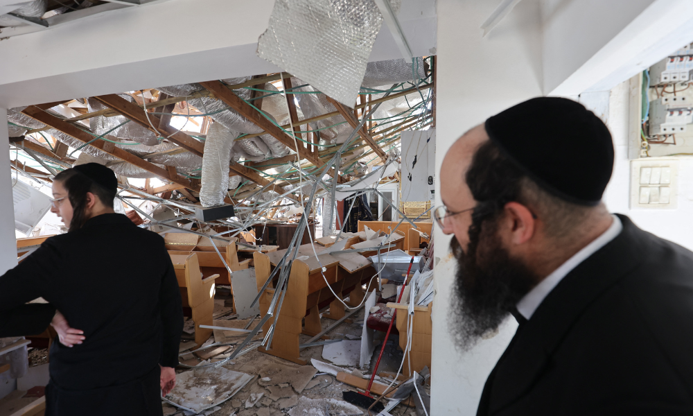 FOTO PRINCIPAL - Pessoas inspecionam os danos dentro de uma sinagoga no local de um ataque de mísseis iranianos em Moshav Zavdiel, perto de Kiryat Gat, no sul de Israel, em 16 de junho de 2025. O Irã desencadeou uma série de ataques de mísseis contra cidades israelenses na manhã de 16 de junho, após Israel atingir alvos militares no interior do Irã, com ambos os lados ameaçando causar ainda mais devastação. (Foto de GIL COHEN-MAGEN / AFP)