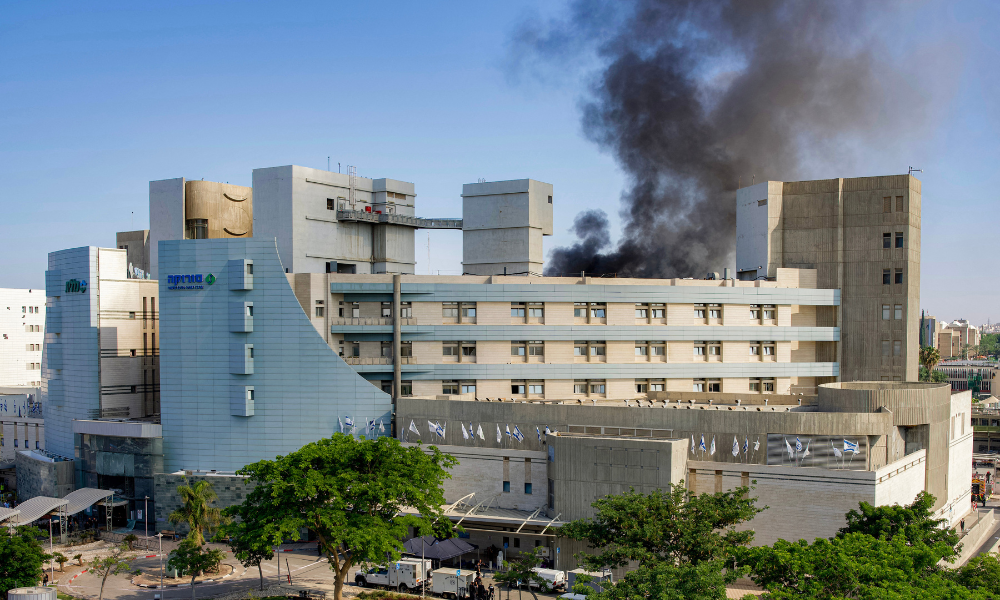 Fumaça sai de um prédio do Hospital Soroka, em Bersheba, no sul de Israel, após um ataque com mísseis iranianos, em 19 de junho de 2025. Um hospital no sul de Israel foi atingido por uma barragem de "dezenas" de mísseis iranianos em 19 de junho, disseram autoridades, enquanto outro impacto foi relatado pelos serviços de emergência na área de Tel Aviv. (Foto de MAYA LEVIN / AFP)