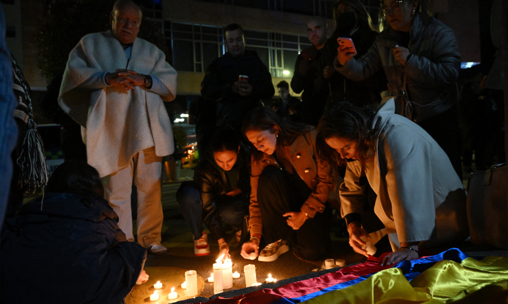 Pessoas acendem velas do lado de fora da Clínica Fundación Santa Fe, onde o senador Miguel Uribe Turbay recebe atendimento médico após ter sido baleado em Bogotá, em 7 de junho de 2025. O senador colombiano de oposição e pré-candidato à presidência nas eleições do próximo ano, Miguel Uribe Turbay, de 39 anos, foi baleado e ferido em Bogotá, segundo diversos meios de comunicação, enquanto o governo classificou o caso como um "atentado". (Foto: Raul Arboleda / AFP)