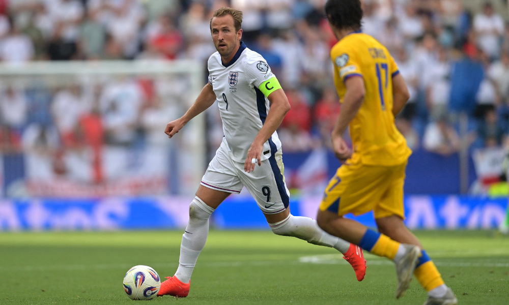 O atacante da Inglaterra, camisa 09, Harry Kane, é desafiado pelo meio-campista de Andorra, camisa 17, Joan Cervós, durante a partida das eliminatórias europeias da Copa do Mundo de 2026, 1ª rodada do grupo K, entre Andorra e Inglaterra, no Estádio RCDE, em Cornella de Llobregat, em 7 de junho de 2025. (Foto: Manaure Quintero / AFP)