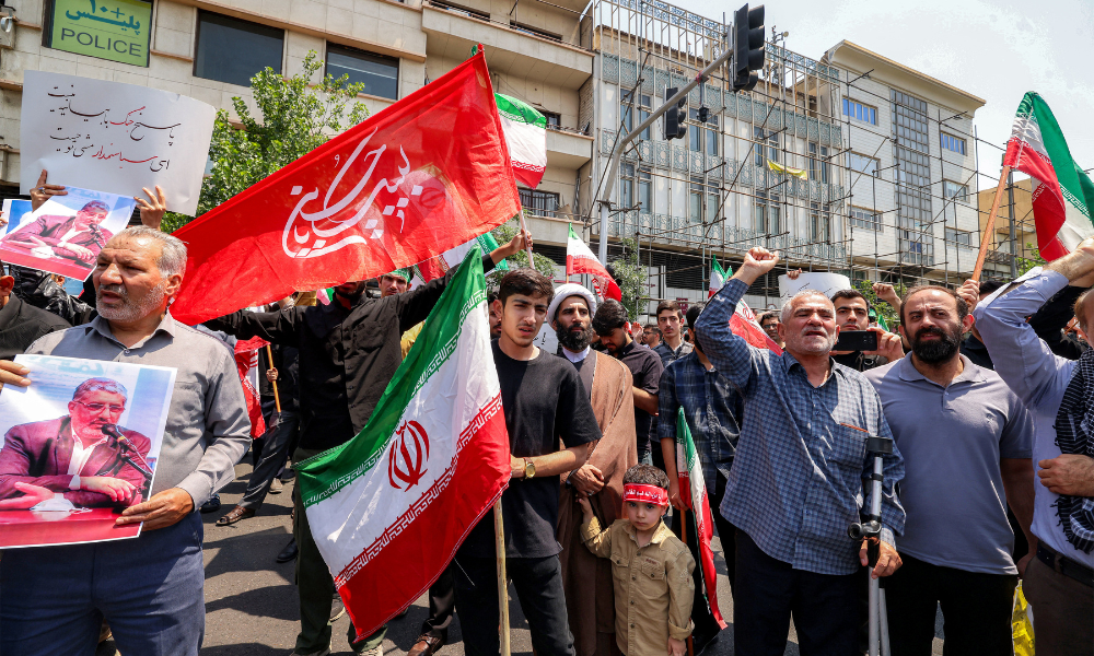 Pessoas se reúnem para um protesto contra a onda de ataques israelenses contra o Irã no centro de Teerã, em 13 de junho de 2025. Israel atingiu cerca de 100 alvos no Irã em 13 de junho, incluindo instalações nucleares e centros de comando militar, matando figuras importantes, como o chefe das Forças Armadas e importantes cientistas nucleares. (Foto de ATTA KENARE / AFP)
