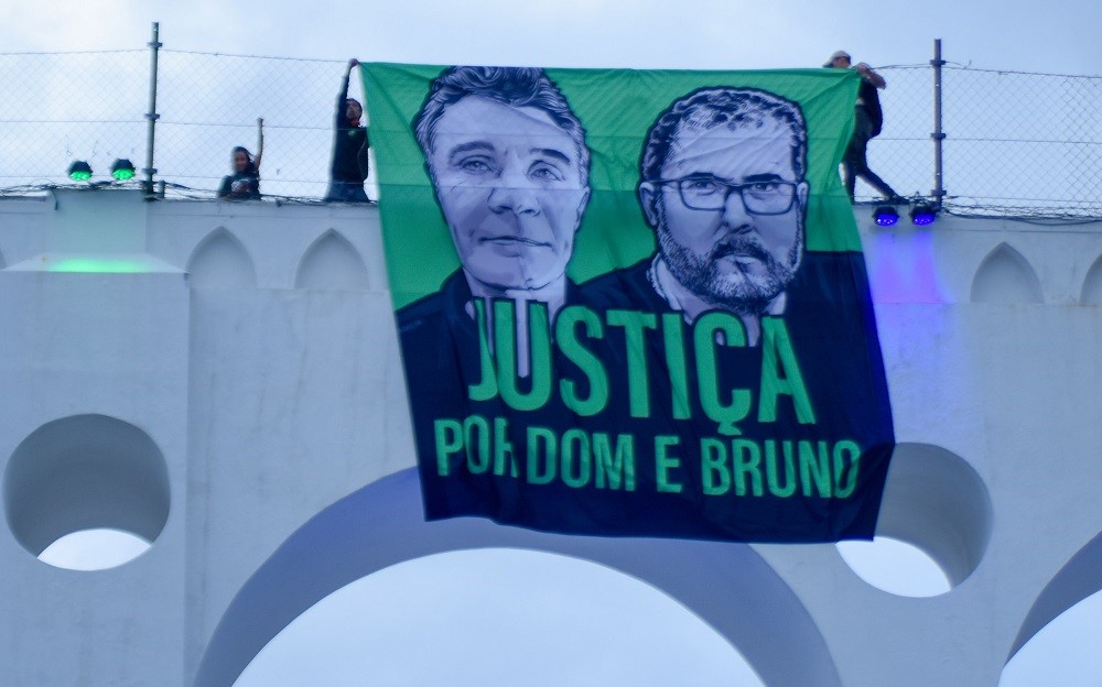 Bandeira com rostos de Dom Phillips e Bruno Pereira pedido de "justiça" por eles é colocado no alto dos Arcos da Lapa