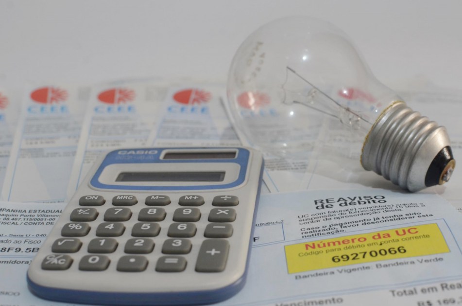 Conta de energia elétrica, lâmpada e calculadora
