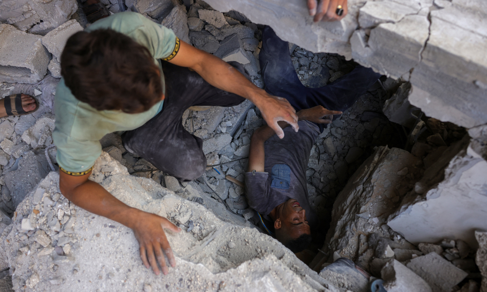 Palestinos procuram sobreviventes nos escombros de um prédio no bairro de Sheikh Radwan, na Cidade de Gaza, no centro da Faixa de Gaza, alvo de um ataque israelense em 6 de julho de 2025. Uma delegação israelense era esperada em Doha em 6 de julho para negociações sobre uma trégua em Gaza e um acordo para a libertação de reféns, após o grupo palestino Hamas afirmar estar pronto para iniciar as negociações "imediatamente". (Foto de Bashar TALEB / AFP)