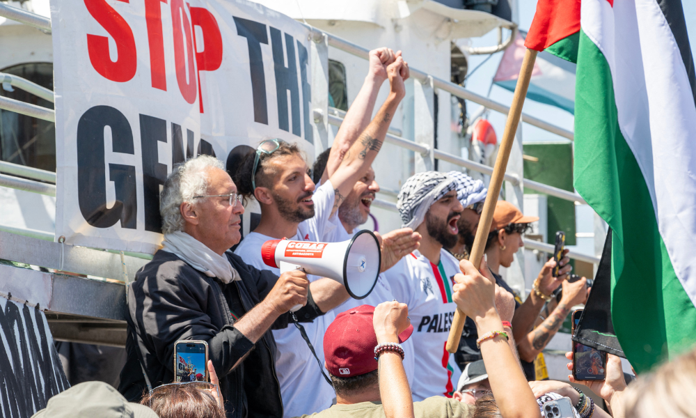 Membros da tripulação comparecem à partida do barco "Handala", da Flotilha da Liberdade, para Gaza, em um porto em Siracusa, Sicília, sul da Itália, em 13 de julho de 2025. Um barco com destino a Gaza, transportando ativistas pró-palestinos e ajuda humanitária, deixou a Sicília em 13 de julho de 2025, mais de um mês depois de Israel ter detido e deportado pessoas a bordo de uma embarcação anterior, que transportava cerca de quinze ativistas. (Foto de Giovanni ISOLINO / AFP)