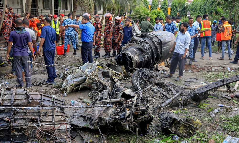 IMAGEM PRINCIPAL - O corpo de bombeiros e a equipe de segurança de Bangladesh realizam uma operação de busca e salvamento após um jato de treinamento da Força Aérea ter caído em uma escola em Daca, em 21 de julho de 2025. Um caça de treinamento de Bangladesh caiu em uma escola na capital, Daca, em 21 de julho, matando pelo menos 19 pessoas e ferindo dezenas no acidente de aviação mais mortal do país em décadas. (Foto de Jubair Bin IQBAL / AFP)