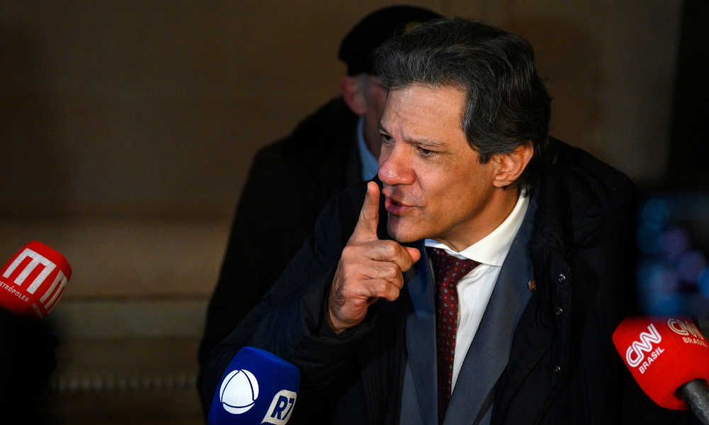 O ministro da Economia do Brasil, Fernando Haddad, fala com a imprensa em frente à casa do embaixador brasileiro em Buenos Aires, em 2 de julho de 2025, durante a 66ª Cúpula de Líderes do Mercosul e Estados Associados. Líderes do bloco sul-americano do Mercosul realizarão dois dias de negociações em Buenos Aires, com foco em um acordo comercial de grande porte com a União Europeia, que está sendo bloqueado pela França. (Foto de LUIS ROBAYO / AFP)