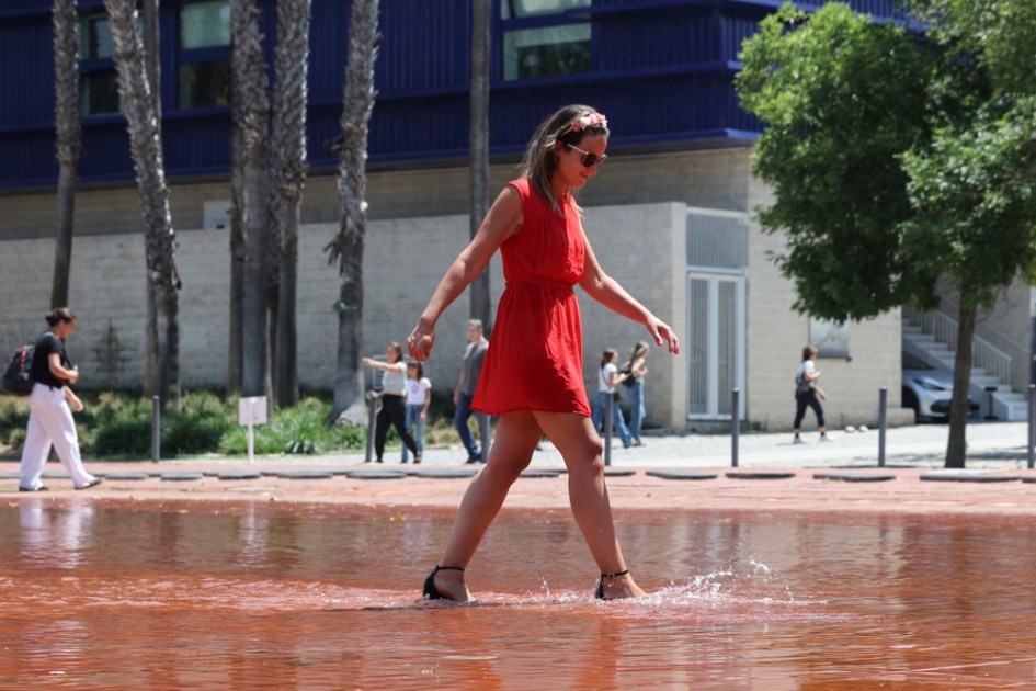 Mulher se refresca em uma fonte em Lisboa