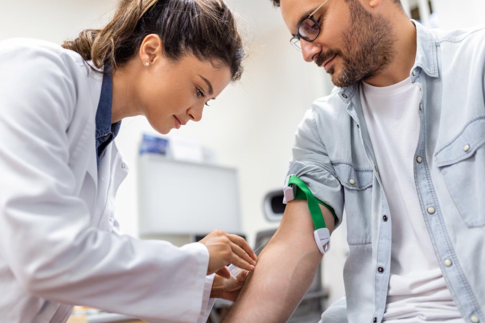 Amigável flebotomista do hospital coletando amostra de sangue do paciente