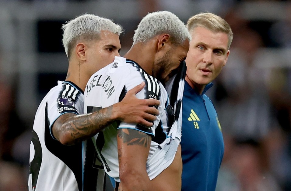 Joelinton (C), do Newcastle, deixa o campo lesionado e é consolado pelo companheiro Bruno Guimarães (E) durante partida da Premier League contra o Liverpoo