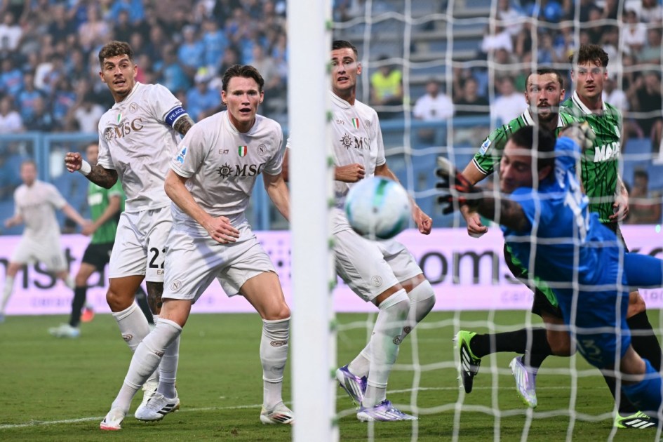 Giovanni Di Lorenzo (#22), e o meio-campista escocês Scott McTominay (#8) observam a bola enquanto o goleiro italiano do Sassuolo, Stefano Turati (#13), não consegue defender o gol marcado pelo meia belga Kevin De Bruyne (#11, fora da imagem)