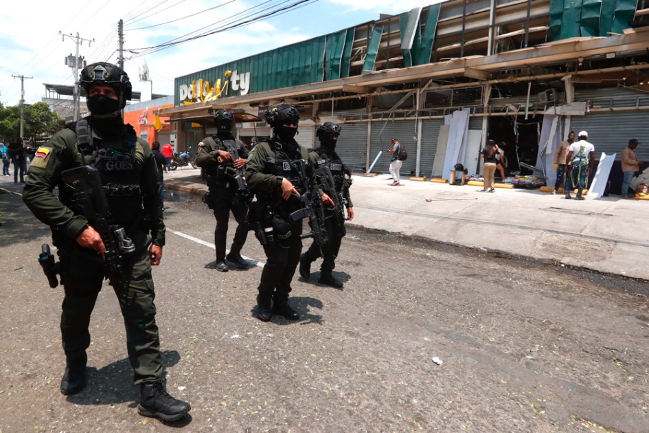 Integrantes dos Grupos Operacionais Especiais de Segurança (GOES) fazem a guarda de estabelecimentos comerciais afetados pela explosão, nesta sexta-feira, em Cali