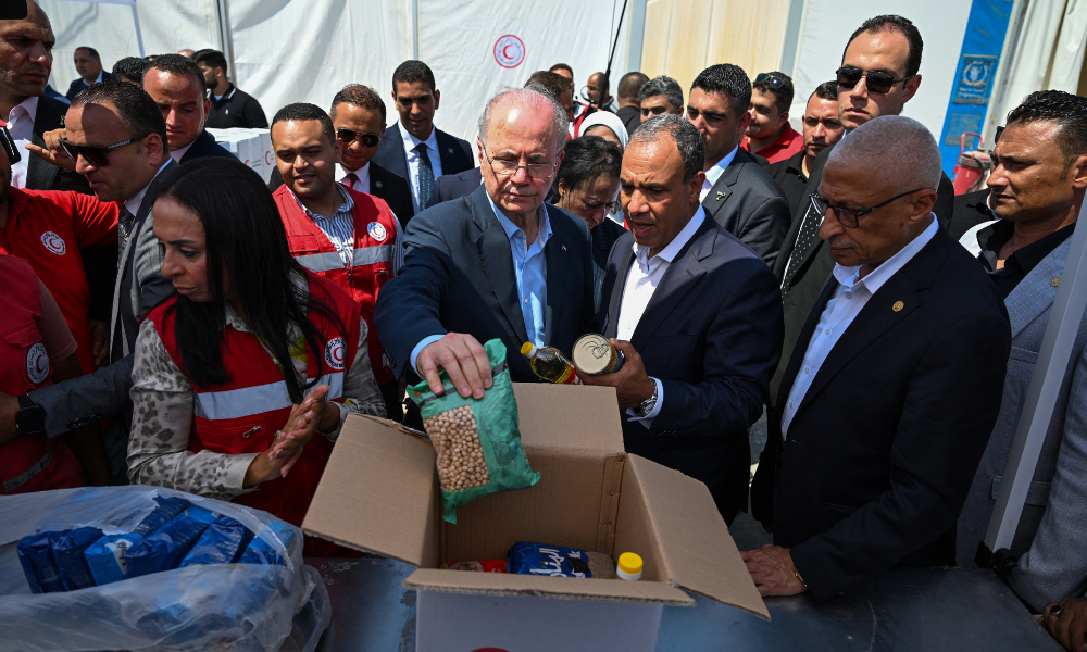 O primeiro-ministro palestino Mohammad Mustafa (C), acompanhado pelo ministro das Relações Exteriores do Egito, Badr Abdelatty (C-D), visita um depósito da Sociedade do Crescente Vermelho que prepara ajuda humanitária para Gaza, em El-Arish, em 18 de agosto de 2025. Negociadores do Hamas no Cairo receberam uma nova proposta de cessar-fogo em Gaza, solicitando uma trégua inicial de 60 dias e a libertação de reféns em dois lotes, disse uma autoridade palestina em 18 de agosto. (Foto de Khaled DESOUKI / AFP)