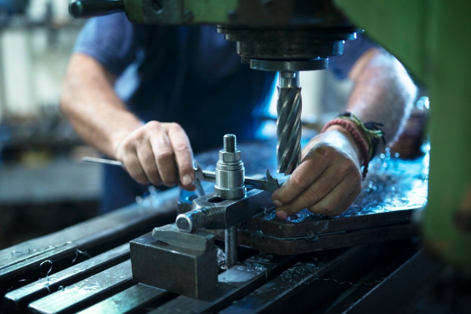Trabalhador operando máquina industrial em uma oficina de metal