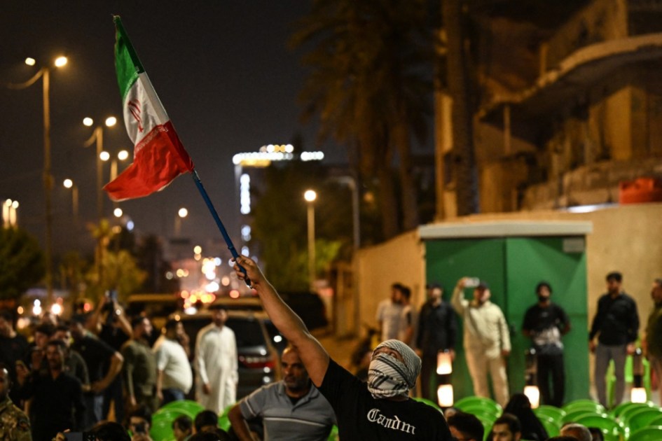 Uma manifestante empunha uma bandeira do Irã durante um protesto contra o ataque de Israel ao país