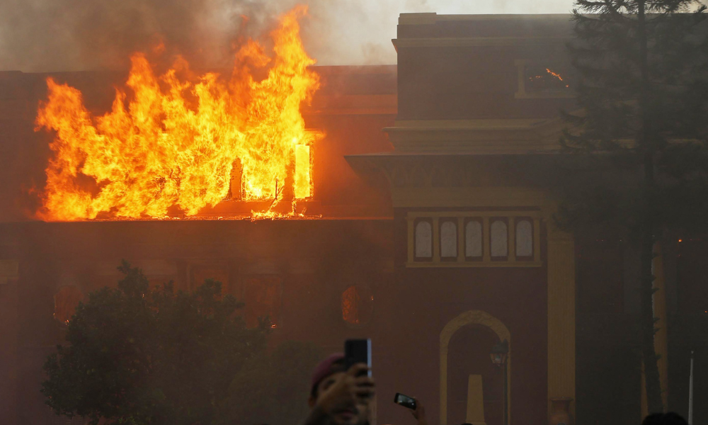 IMAGEM PRINCIPAL - Fumaça sai da Casa Presidencial em chamas, incendiada por manifestantes em Katmandu em 9 de setembro de 2025, um dia após a repressão policial a manifestações contra a proibição de redes sociais e a corrupção governamental. O presidente do Nepal apelou à unidade nacional em 9 de setembro, após dois dias de protestos violentos, incluindo manifestações contra a proibição governamental de redes sociais, que forçou a renúncia do primeiro-ministro e deixou pelo menos 19 mortos. (Foto de Prabin RANABHAT / AFP)