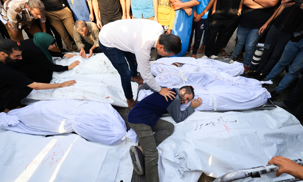 NOTA DO EDITOR: Conteúdo gráfico / Um parente lamenta os corpos dos membros da família Abu Morad, que morreram após ataques israelenses, durante seu funeral em Khan Yunis, no sul da Faixa de Gaza, em 24 de outubro de 2023, em meio aos conflitos entre Israel e o grupo palestino Hamas. (Foto de Mahmud HAMS / AFP)