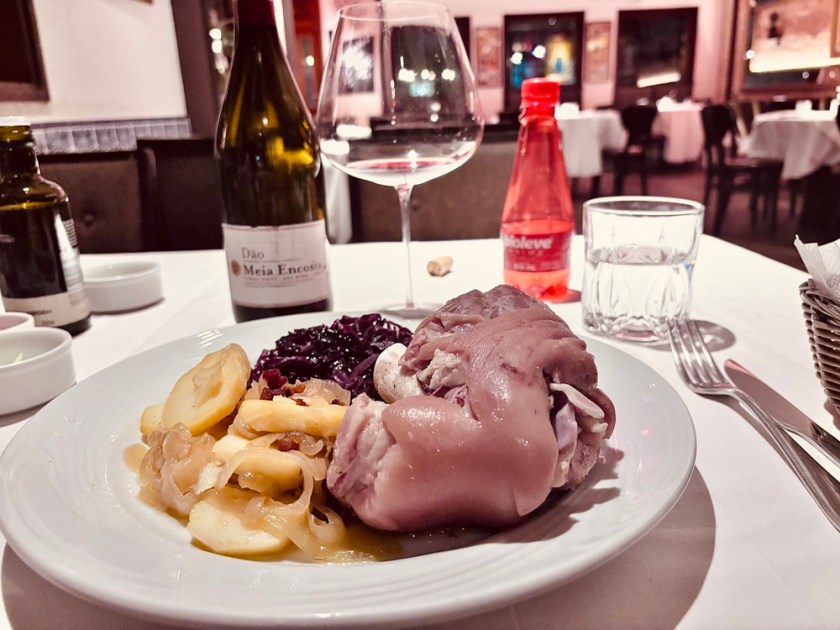 Ptrato alemão na mesa de restaurante acompanhado de garrafa de vinho