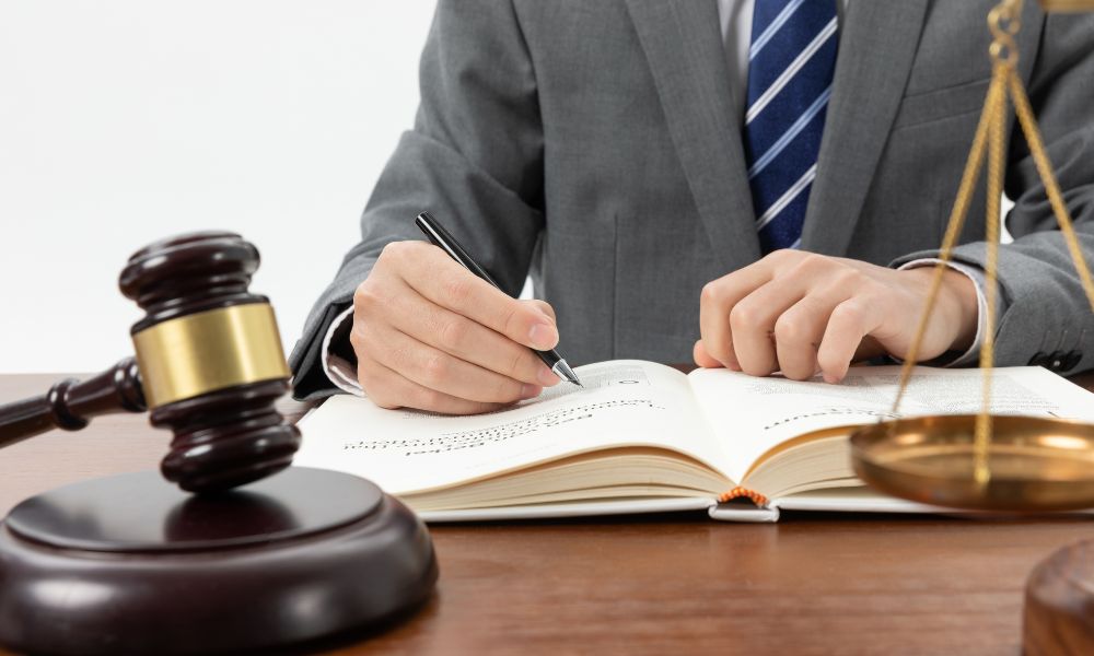 Foto de pessoa escrevendo com um martelo à frente