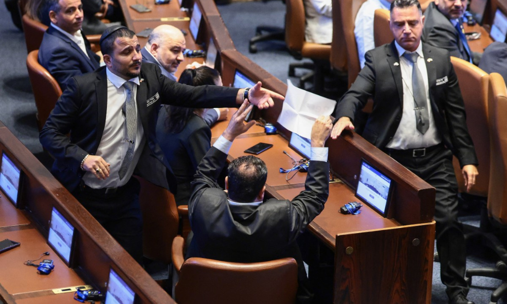 Parlamentar israelense Ayman Odeh segura uma placa com os dizeres 'Reconhecer a Palestina' durante discurso de Trump no Parlamento israelense