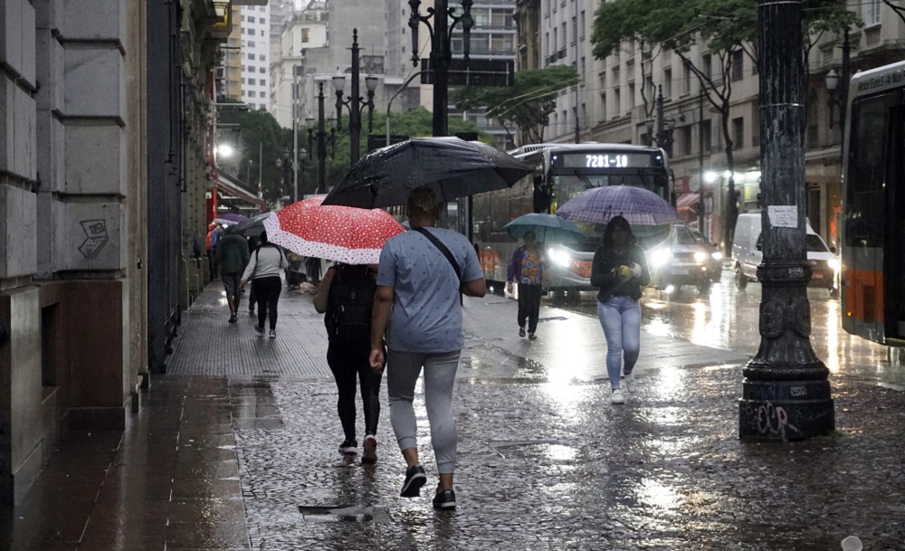 Pedestres se protegem da chuva na região central de São Paulo